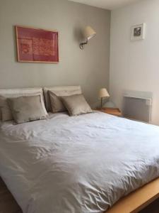 ein Bett mit weißer Bettwäsche und Kissen in einem Schlafzimmer in der Unterkunft T2 St Martin du Touch AIRBUS Quiet and spacious in Toulouse