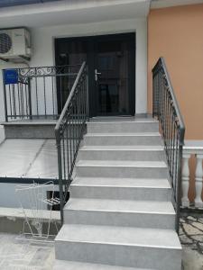 eine Treppe, die zu einer schwarzen Tür führt in der Unterkunft Bruno apartman in Selce