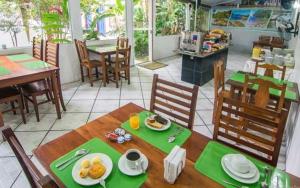 una sala da pranzo con tavolo e cibo di Pousada Lua Clara a Parati