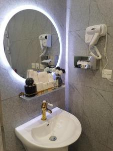 y baño con lavabo y espejo. en غرفة بمساحة واسعة حي الرمال en Riad