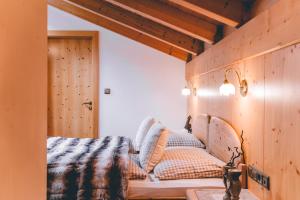 um quarto com uma cama com almofadas em Garni Hotel Belalp em Santa Cristina in Val Gardena