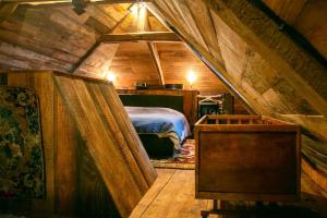 a room with a bed in a attic at Les Maisons du Bonheur & Balnéo in Croze