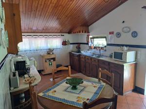 eine Küche mit einem Tisch und einer Arbeitsplatte in der Unterkunft Quinta de Carcavelos Agroturismo e Enoturismo in Celorico de Basto