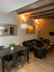 a living room with a couch and a table and chairs at Apartament modern al carrer Blai, Poble Sec in Barcelona