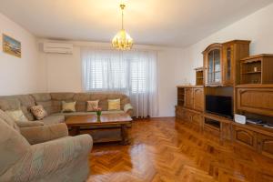 salon z kanapą i telewizorem w obiekcie Apartman Dugeč w mieście Kaštela