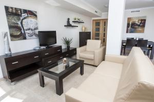 sala de estar con sofá y TV en ESTIMAR Calpe Apartments, en Calpe