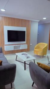 sala de estar con TV, sofá y mesa en Two bedroom apartment in ikeja, en Ikeja