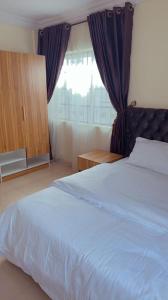 Un dormitorio con una cama grande y una ventana en Two bedroom apartment in ikeja, en Ikeja