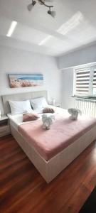 - une chambre avec un grand lit et une couverture rose dans l'établissement Apartament Jenny, à Mangalia