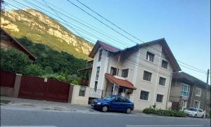 ein blaues Auto, das vor einem Haus parkt in der Unterkunft Casa Peneșel in Băile Herculane