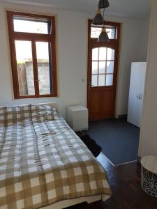 a bedroom with a bed and two windows and a door at F1 centre ville in Bohain-en-Vermandois