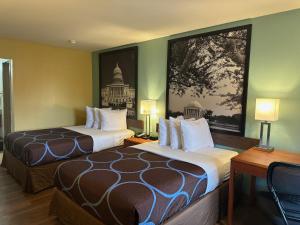 a hotel room with two beds and a painting on the wall at Super 8 by Wyndham WestEnd Alexandria,VA Washington DC Area in Alexandria