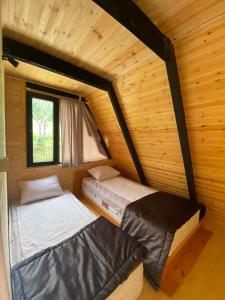 a room with two beds in a log cabin at Inn Martvili in Martvili