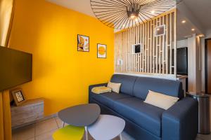 ein Wohnzimmer mit einem blauen Sofa und einer gelben Wand in der Unterkunft Lac-Montagne-Leman-Geneva, Garage, Tram in Annemasse