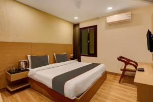 a hotel room with a bed and a television at Collection O Hotel Orange Regency in Dehradun