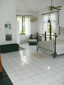 a room with a bedroom with a bed and windows at Tamarind Great House in Oracabessa
