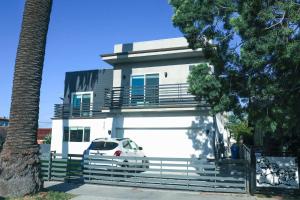 uma casa branca com um carro estacionado em frente dela em 4BR/4BR modern house at Mid-city em Los Angeles