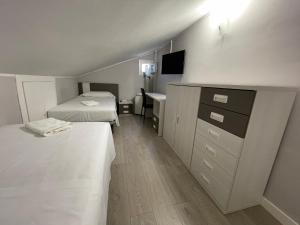 Habitación con 2 camas, escritorio y lavabo. en La Rosa Azul Rooms, en Ponferrada
