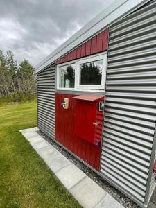 a red door and window on the side of a trailer at Stunning house - amazing scenery in Hvolsvöllur