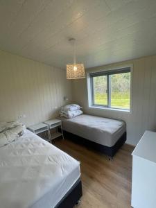 1 dormitorio con 2 camas y ventana en Stunning house - amazing scenery, en Hvolsvöllur