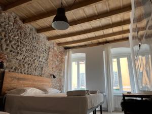 a bedroom with a bed and a brick wall at Borgovivobg il tuo rifugio in centro città in Bergamo