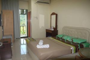 ANZ LANGKAWI INN في بانتايْ سينانج: غرفة نوم بسريرين مع مرآة ونافذة