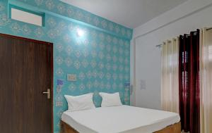 a bedroom with a bed and a blue wall at Hotel Surya Inn in Pura Raghunāth