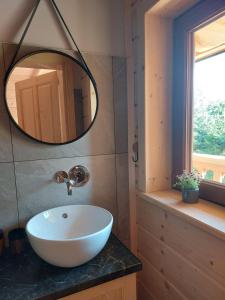 a bathroom with a white sink and a mirror at Osada Witów - Domek we wsi in Witów