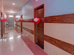 un couloir avec des ballons rouges sur le mur dans l'établissement Hotel Surya Inn, à Pura Raghunāth