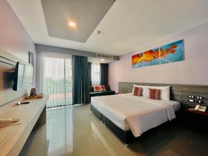 une chambre d'hôtel avec un lit et une télévision dans l'établissement Arthitaya Green Nature Hotel, à Pattaya (nord)