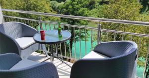 uma varanda com cadeiras e uma mesa com uma garrafa de vinho em Apartmani City Foča em Foca