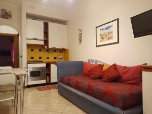 a living room with a red couch and a kitchen at BB45 in Palermo