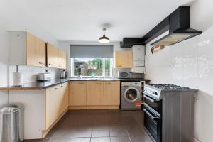 a kitchen with a stove and a dishwasher at Sleek and Stylish 3 Bed House - Great Location in Bolton
