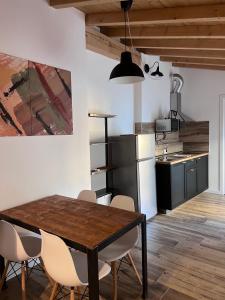 a kitchen and dining room with a wooden table and chairs at Borgovivobg il tuo rifugio in centro città in Bergamo