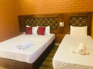two beds in a room with towels on them at Monaara Leisure - Anuradhapura in Anuradhapura