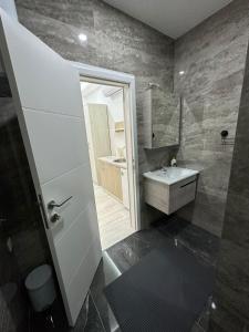 uma casa de banho com um lavatório e um espelho em Apartmani City Foča em Foca