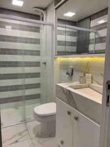 uma casa de banho com um WC, um chuveiro e um lavatório. em ALTO PADRÃO centro de Criciúma em Criciúma