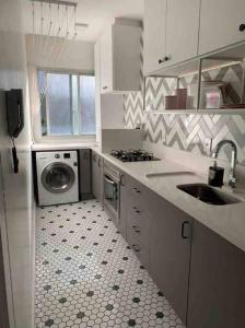 a kitchen with a sink and a washing machine at ALTO PADRÃO centro de Criciúma in Criciúma