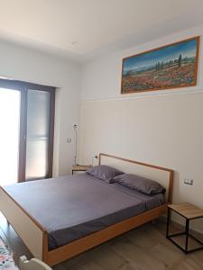 1 dormitorio con 1 cama y una foto en la pared en Bordoriva, en Formia