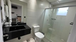 La salle de bains est pourvue de toilettes et d'une douche en verre. dans l'établissement Studios 422, à Pomerode