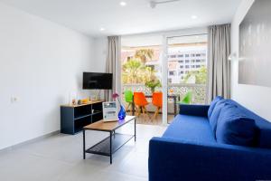 a living room with a blue couch and a table at Apartment in Playa de las Americas in Playa de las Americas