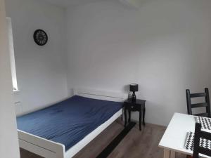 sypialnia z łóżkiem, stołem i zegarem w obiekcie Apartament Rychwałd w mieście Rychwałd