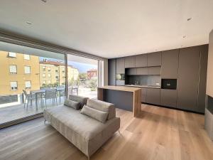 een woonkamer met een bank en een groot raam bij AD Suite Apartment in Riva del Garda