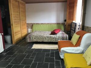ein Schlafzimmer mit einem Bett, einem Sofa und einem Stuhl in der Unterkunft Casas da Nascente in Loriga