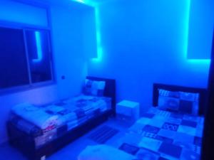 een kamer met 2 bedden en een blauw licht bij Disney land villa in Gourizim