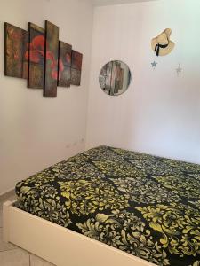 a bed in a room with paintings on the wall at Sea Paradise Apartment in Valledoria