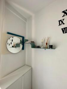 Habitación blanca con espejo y estante en Celio 83 Luxury, en Roma
