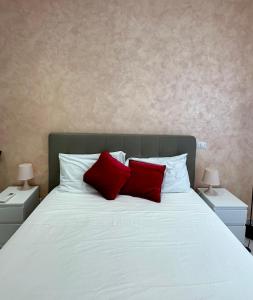 Una cama blanca con dos almohadas rojas. en Celio 83 Luxury, en Roma