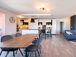 een keuken en een woonkamer met een houten tafel en stoelen bij Le Luxury - Rooftop - Circuit - 4 pers in Le Mans