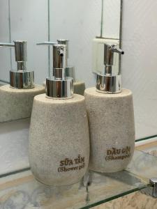 a group of three soap dispensers sitting on a shelf at Hidden gem homestay 2 in Hanoi